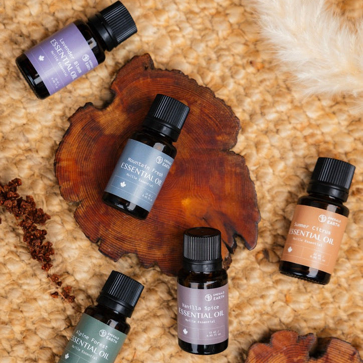 Five essential oil bottles on a textured surface with wooden elements