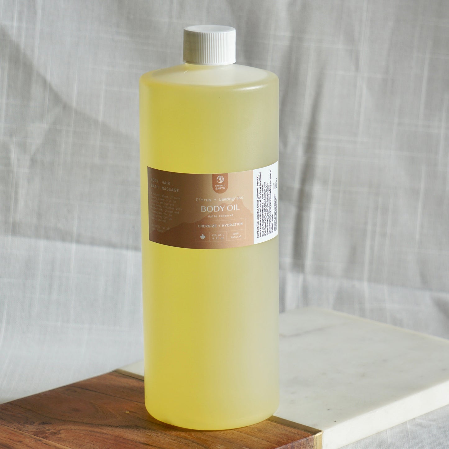 Bottle of yellow liquid on a wooden cutting board with a white background