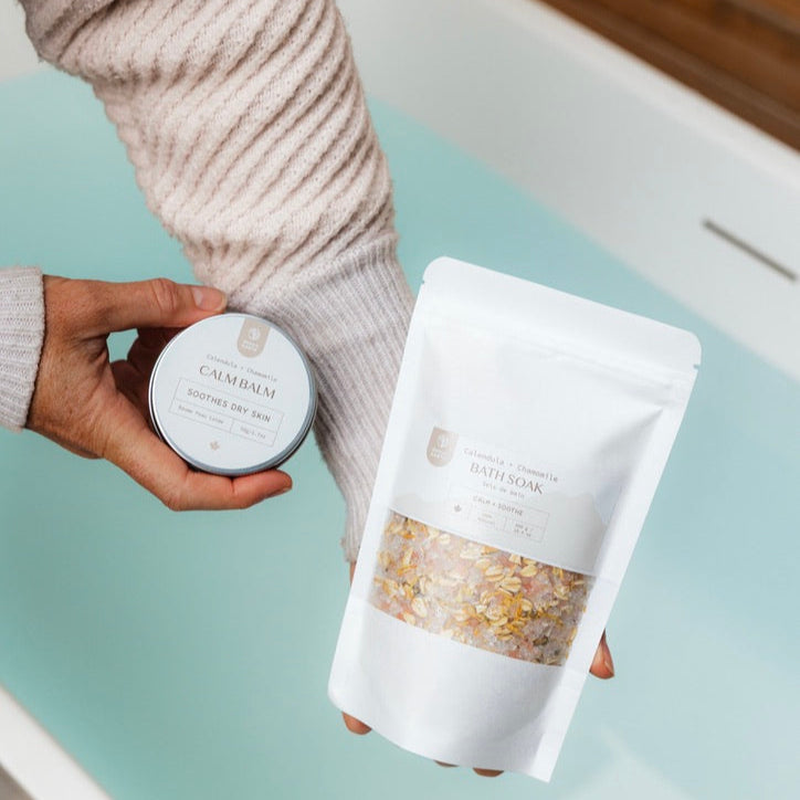 Person holding a jar and a package of a product on a light blue surface.