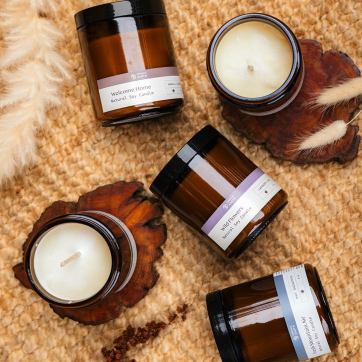 Five brown candles with white labels on a textured surface