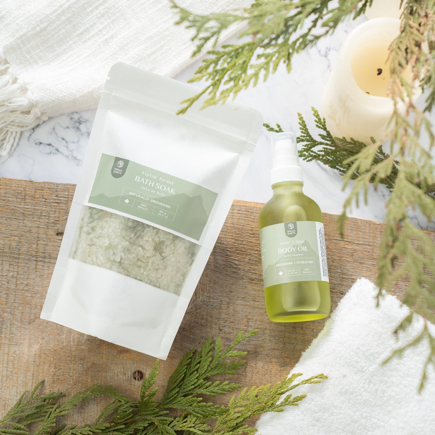 Bottle of green liquid, white package, and white towel on a wooden surface with greenery.