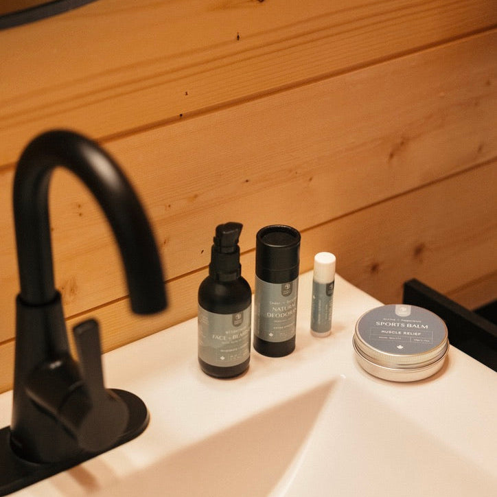 Bathroom sink with skincare products on a wooden wall background