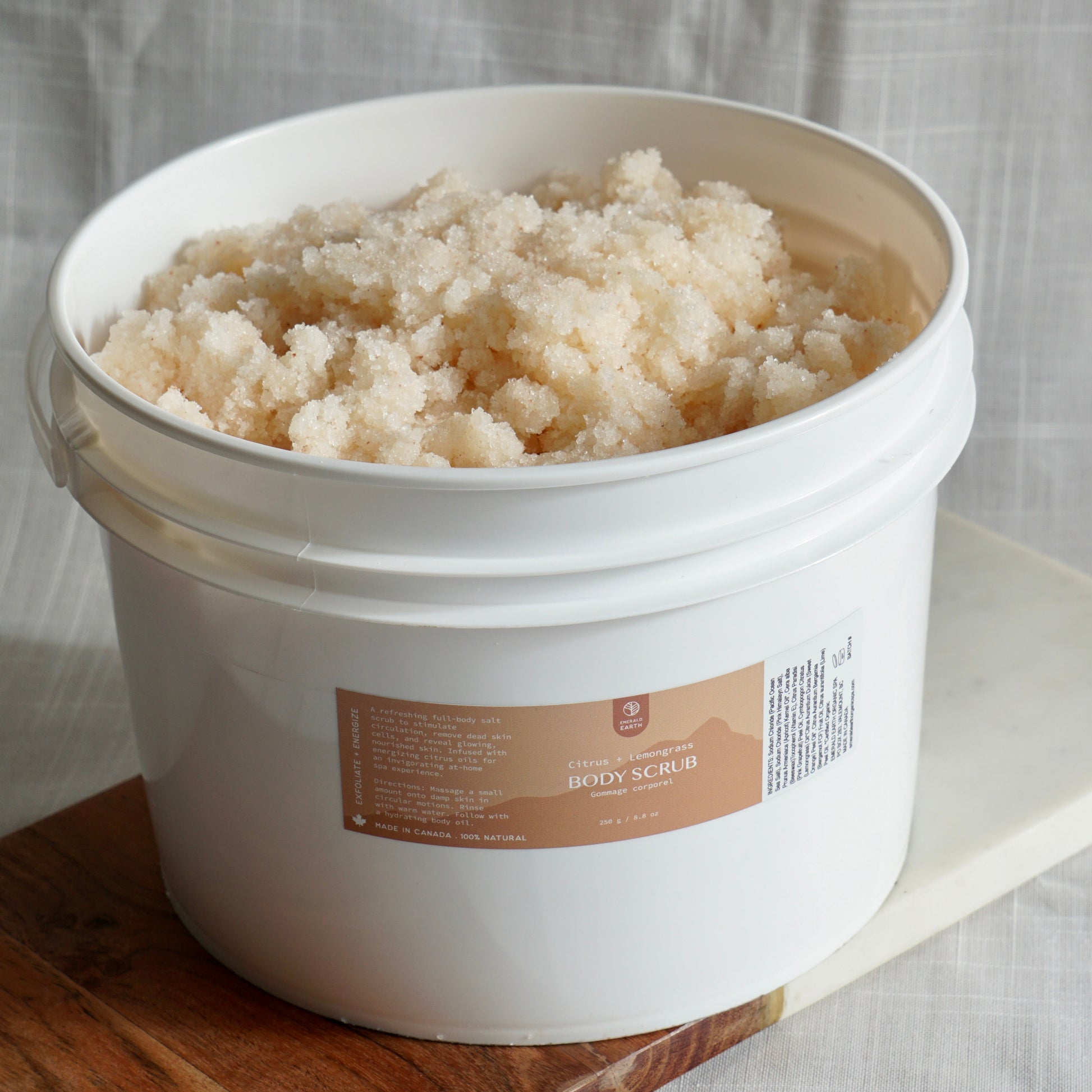 White bucket of body scrub with a label on a wooden surface