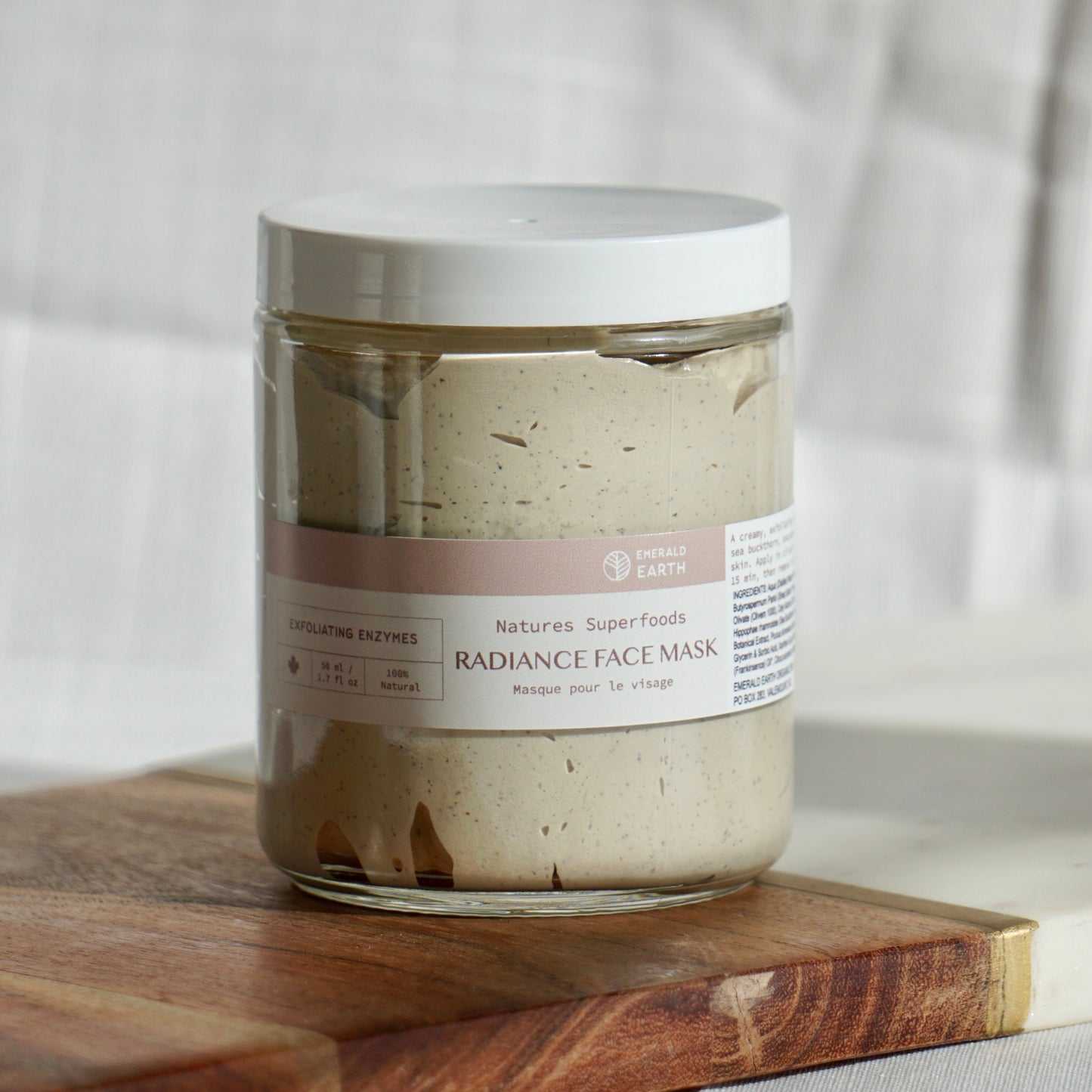 Jar of face mask on a wooden board with a neutral background