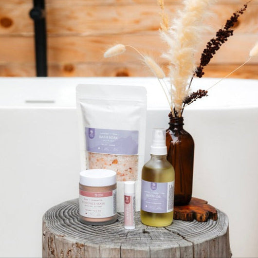 Bath products on a wooden stool with a bathtub and wooden wall in the background