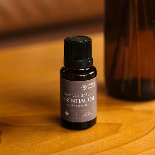 Vanilla extract bottle and essential oil dropper on a wooden surface with a blurred background