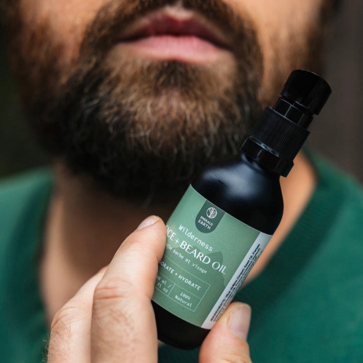 Man holding a bottle of beard oil with a blurred background