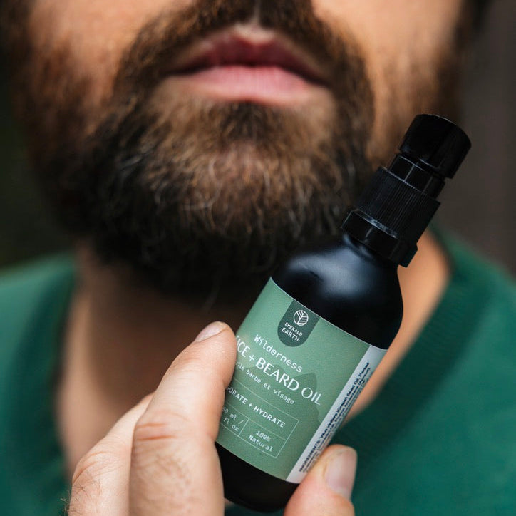 Man holding a bottle of beard oil with a blurred background