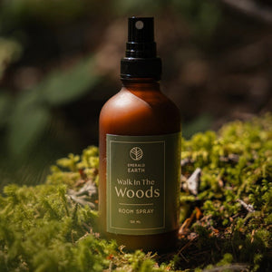 Room spray bottle labeled 'Walk in the Woods' on a mossy background