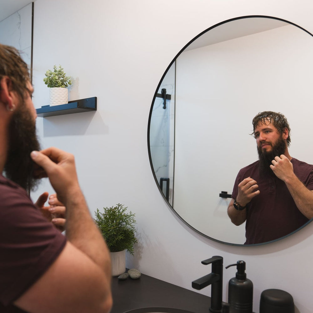 Putting on beard oil in mirror after shower